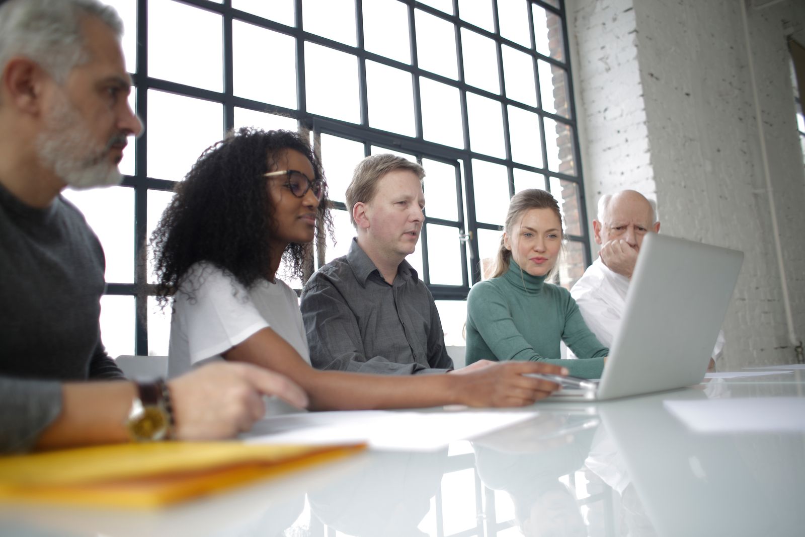 An international team collaborating around a laptop